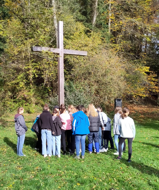 Konfis vor einem Holzkreuz